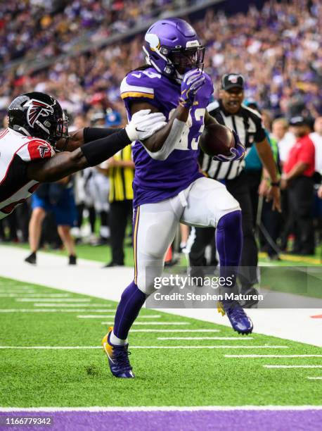 Dalvin Cook of the Minnesota Vikings runs with the ball for a touchdown as Keanu Neal of the Atlanta Falcons runs defense in the first quarter of the...