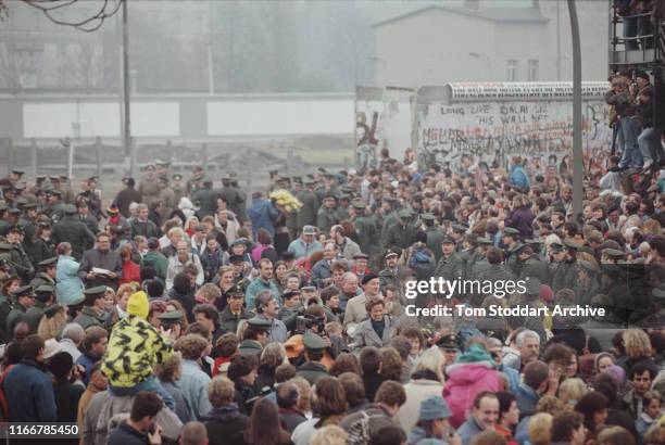 Crowds celebrating the fall of the Berlin Wall in the formerly divided Potsdamer Platz, 12th November 1989. The border between East and West Berlin...