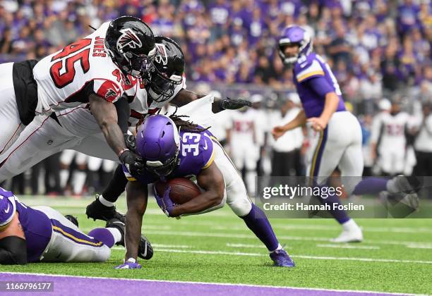 Richie Brown and De'Vondre Campbell of the Atlanta Falcons tackle Dalvin Cook of the Minnesota Vikings just short of the goal line during the second...