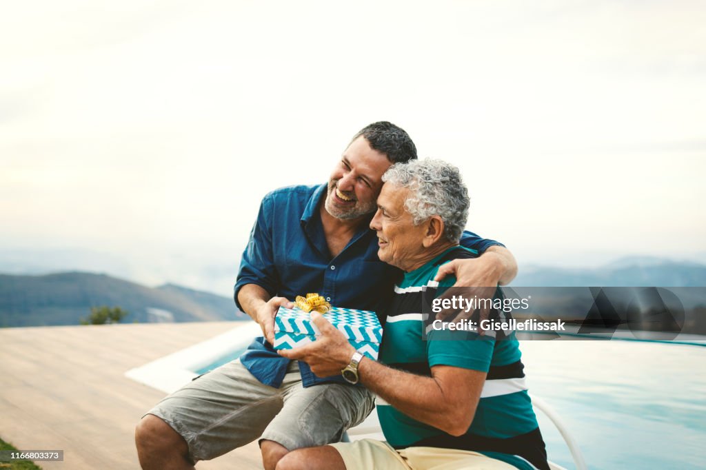 Son giving a gift for his father on father's day.