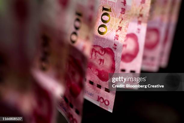 chinese one hundred yuan banknotes on black background - billete de yuan chino fotografías e imágenes de stock