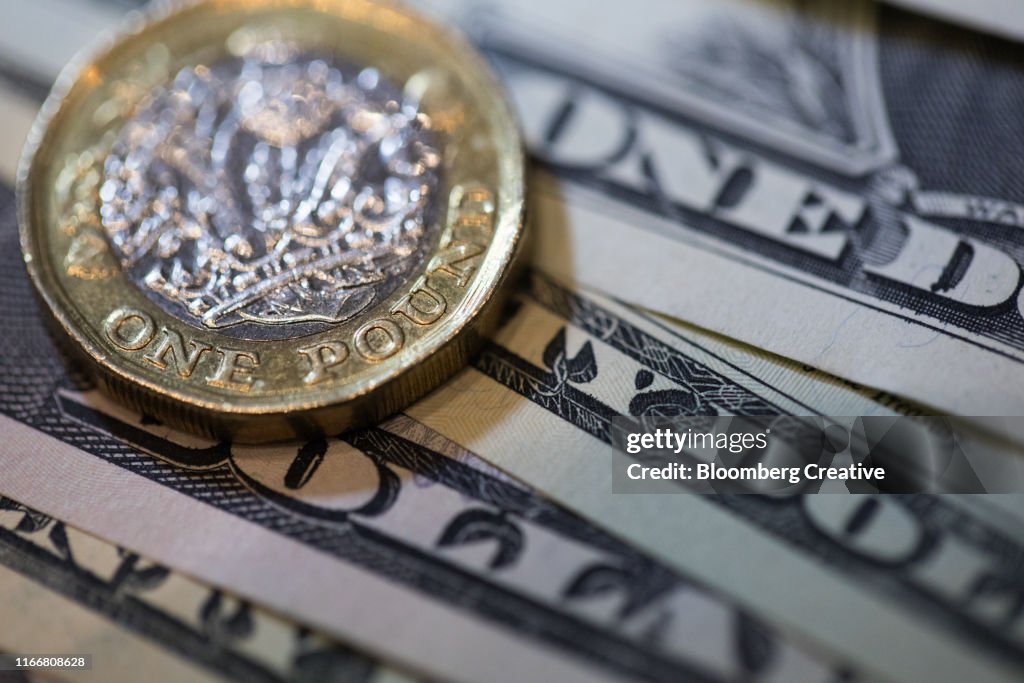 British One Pound Coin And American One Dollar Bills