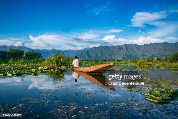 fisherman in his shikara canoe on lake dal, india - dal lake imagens e fotografias de stock