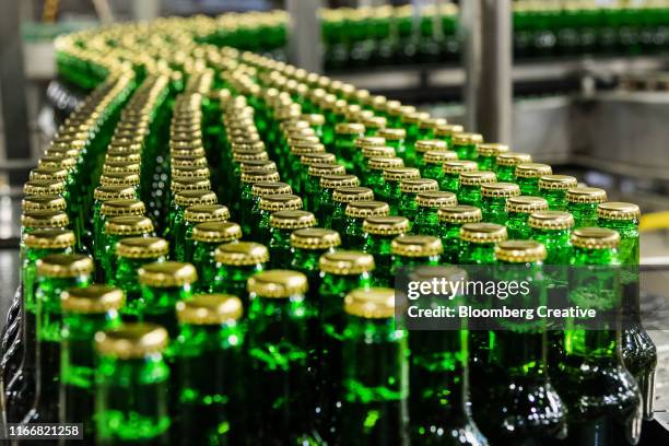 capped glass beer bottles - brouwerij stockfoto's en -beelden