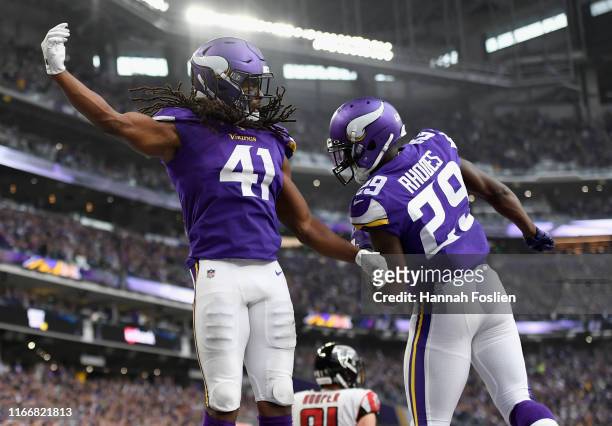 Anthony Harris and Xavier Rhodes of the Minnesota Vikings celebrate an interception in the end zone against the Atlanta Falcons by Harris during the...