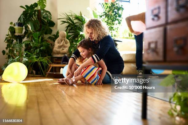 grandmother helping young girl to put on shoes - aunt ストックフォトと画像