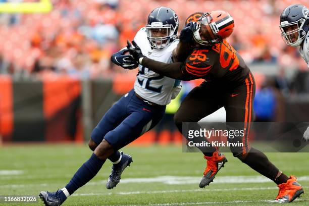 Derrick Henry of the Tennessee Titans grabs the face mask of Myles Garrett of the Cleveland Browns while fighting for positive yards during the...
