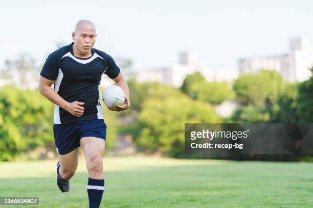 rugbyspeler holding rugby bal en running - rugby union tournament stockfoto's en -beelden