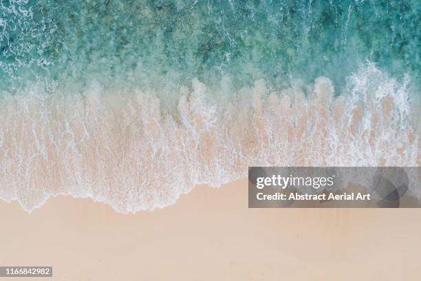 wave textures washing onto a caribbean beach shot from above, barbados - beach waves fotografías e imágenes de stock