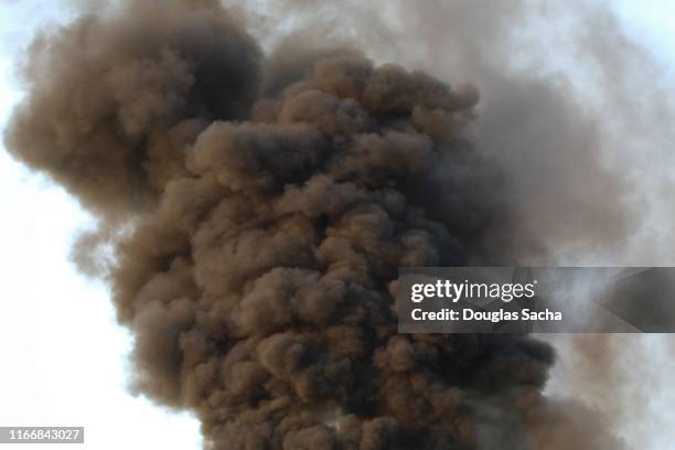 thick black smoke in the clear sky - black smoke stock-fotos und bilder