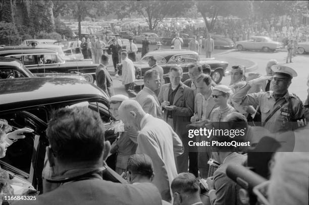 Accompanied by his wife, First Lady Mamie Eisenhower , US President Dwight D Eisenhower leaves Walter Reed Hospital , surrounded by reporters and...