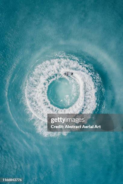 circle patterns created by jet ski at sea as seen from directly above, barbados - peeple of caribbean stock-fotos und bilder