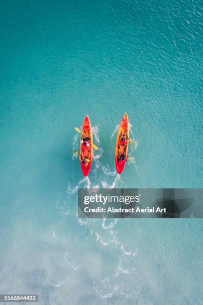 kayaks racing in shallow ocean water as seen from above, barbados - drone point of view - fotografias e filmes do acervo