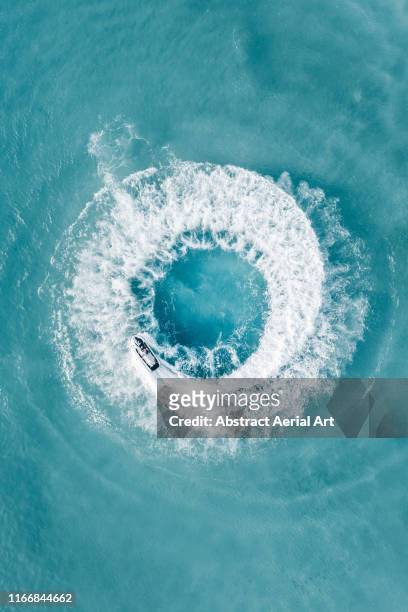 jet ski doing circles shot by drone, barbados - motor boat photos et images de collection