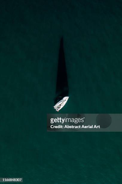drone image above a sailing boat and its shadow, france - yacht top view stock pictures, royalty-free photos & images