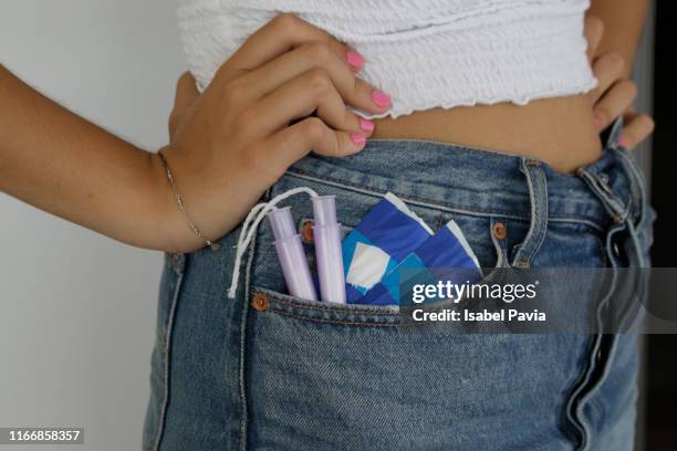 woman with sanitary pads and tampons in pocket - hands in pockets foto e immagini stock