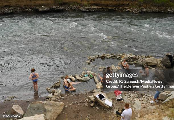 People relax at the Penny Hot Springs located along the Crystal River on August 1, 2019 in Carbondale, Colorado.