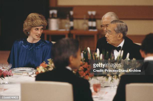 Diana, Princess of Wales with Emperor Hirohito at an imperial banquet in Tokyo, Japan, May 1986. She is wearing a Yuki gown and a jewelled headband.