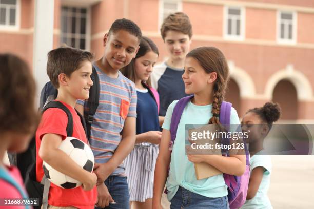 group of school children, friends talking together on campus. - junior high student stock pictures, royalty-free photos & images
