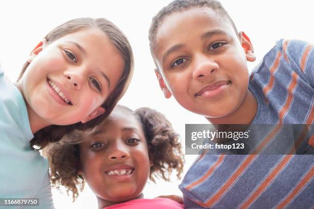multiethnische gruppe von schulkindern freunde in huddle. - middle school stock-fotos und bilder