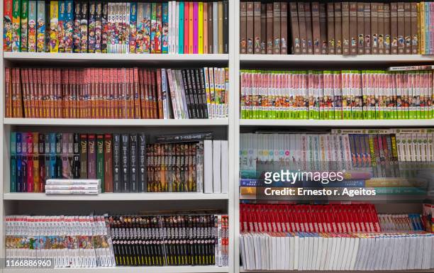 store shelves filled with manga comic books - strip stockfoto's en -beelden