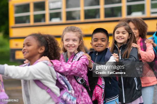 diverse group of students standing outside school bus - lining up imagens e fotografias de stock