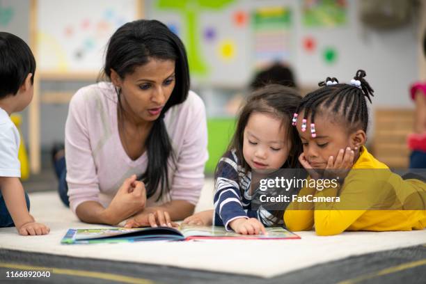 preschool teacher reading with students - development camp stock pictures, royalty-free photos & images