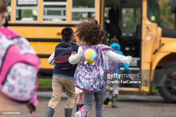 gruppo diversificato di bambini felici che svengono sullo scuolabus - autobus foto e immagini stock