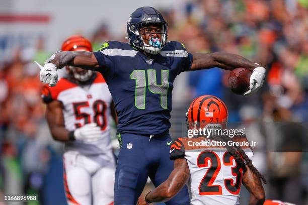 Wide receiver DK Metcalf of the Seattle Seahawks reacts after making a catch against safety Jessie Bates and cornerback B.W Webb of the Cincinnati...