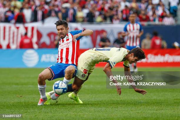 Chivas de Guadalajara forward Oribe Peralta fouls Club America defender Haret Ortega during the first half of the Superclasico 2019 football match on...