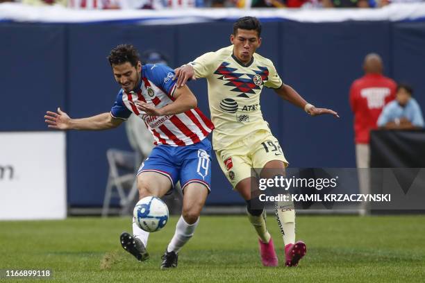 Chivas de Guadalajara defender Antonio Briseno kicks the ball away from Club America forward Jose Lopez Lopez during the first half of the...