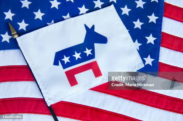 democratic party flag with donkey as its' symbol laying on an american flag. - democratic party usa stock pictures, royalty-free photos & images