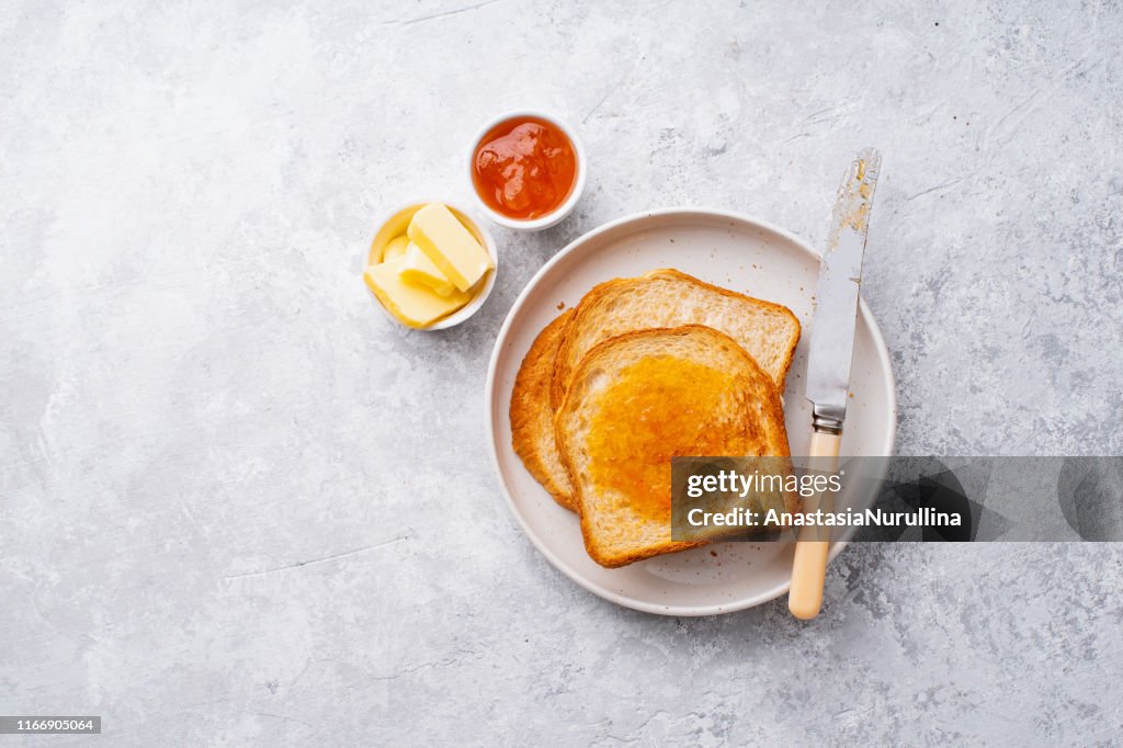 Morning toasts with butter and jam. Top view, copy space.