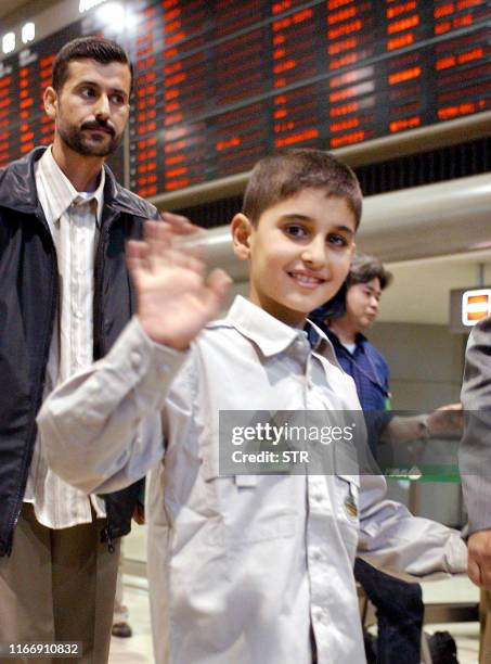 Year-old Iraqi boy Mohamad Haytham Saleh, accompanied by his father Haytham , waves upon his arrival at the New Tokyo International Airport in Narita...