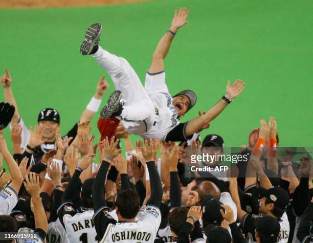 Pacific League champion Nippon Ham Fighters manager Trey Hillman is tossed up in the air by players after they won the Japan Series baseball in...