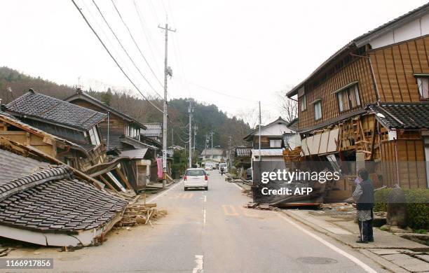 Local resident looks at collapsed houses along a street in Wajima, in Ishikawa prefecture, after a massive earthquake hit northern Japan, 25 March...