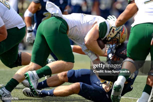 Blazers quarterback Tyler Johnston III and Akron Zips linebacker John Lako hit head-to-head during the fourth quarter of the college football game...