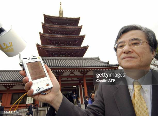 Karyn POUPEE This photo taken 12 April, 2007 shows Japanese professor Ken Sakamura displaying a PDA which displays a guide of scenic spots for...