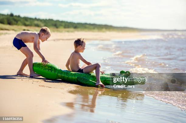 two boys playing in water - toy animal stock pictures, royalty-free photos & images