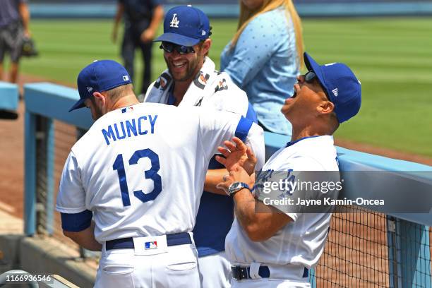 Max Muncy, Clayton Kershaw and manager Dave Roberts of the Los Angeles Dodgers laugh before the game the St. Louis Cardinals in the ninth inning at...