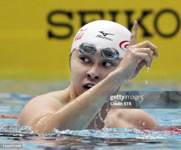 Japan's double Olympic champion Kosuke Kitajima reacts after he set a new world record at the Japan Open swimming championships in Tokyo on June 8,...