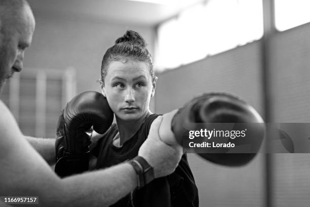 teenage female fighter meisje en trainer in een openbare sportschool - aanvallen sporten stockfoto's en -beelden
