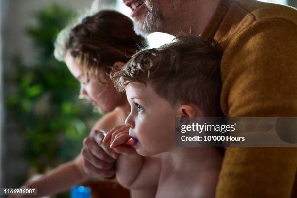 father helping little boy to brush his teeth - learning generation parent child stock pictures, royalty-free photos & images