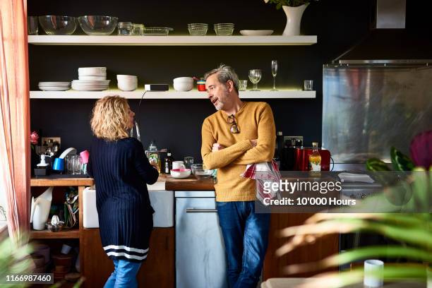 Mature man and woman doing dishes together in kitchen