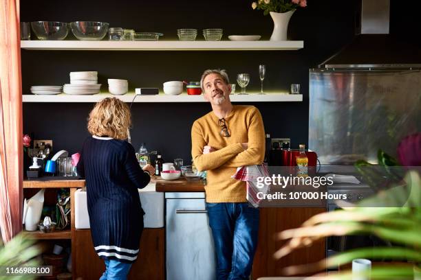 mature man looking up with arms folded with wife - couples showering stock-fotos und bilder