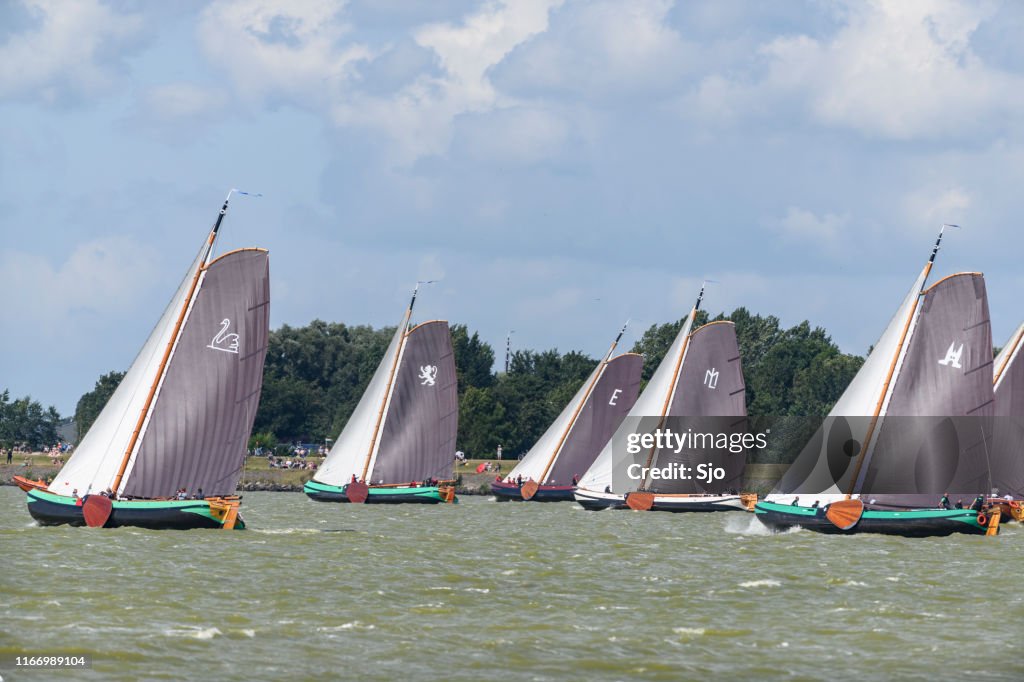 Skutsje veleros clásicos navegando en el IJsselmeer cerca de Lemmer en Frisia durante el Skutsjesilen