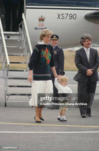 Diana, Princess of Wales arrives at Aberdeen airport in Scotland on The Queen's Flight, with her son Prince Harry, August 1986. She is wearing a...