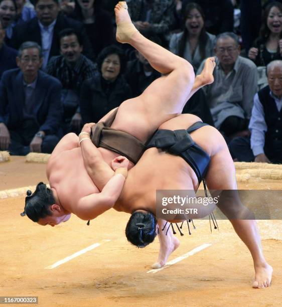 Mongolian grand champion Hakuho is thrown by Aminishiki on the first day bout of the Kyushu Grand Sumo Tournament at Fukuoka city in Fukuoka...