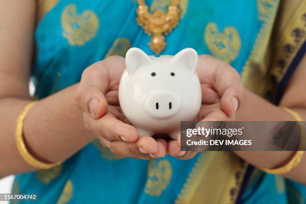 traditional woman holding piggy bank-money savings concept - sari isolated stock pictures, royalty-free photos & images