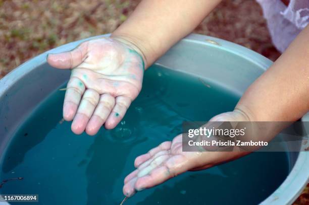 child washing hands in a bucket - washing hands close up stock pictures, royalty-free photos & images